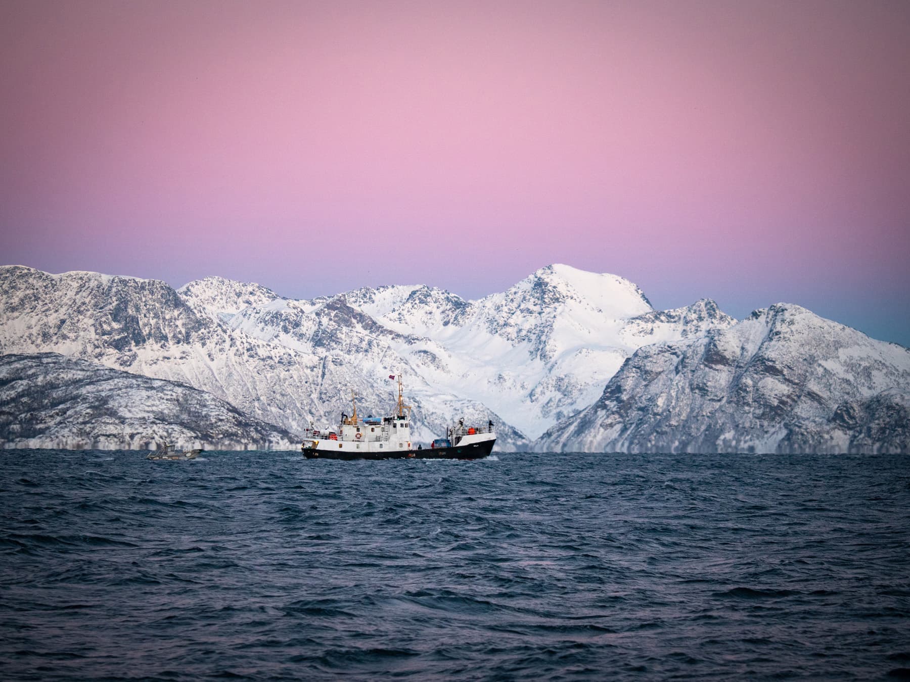 ship steaming with arctic mountains and purple skies in the background